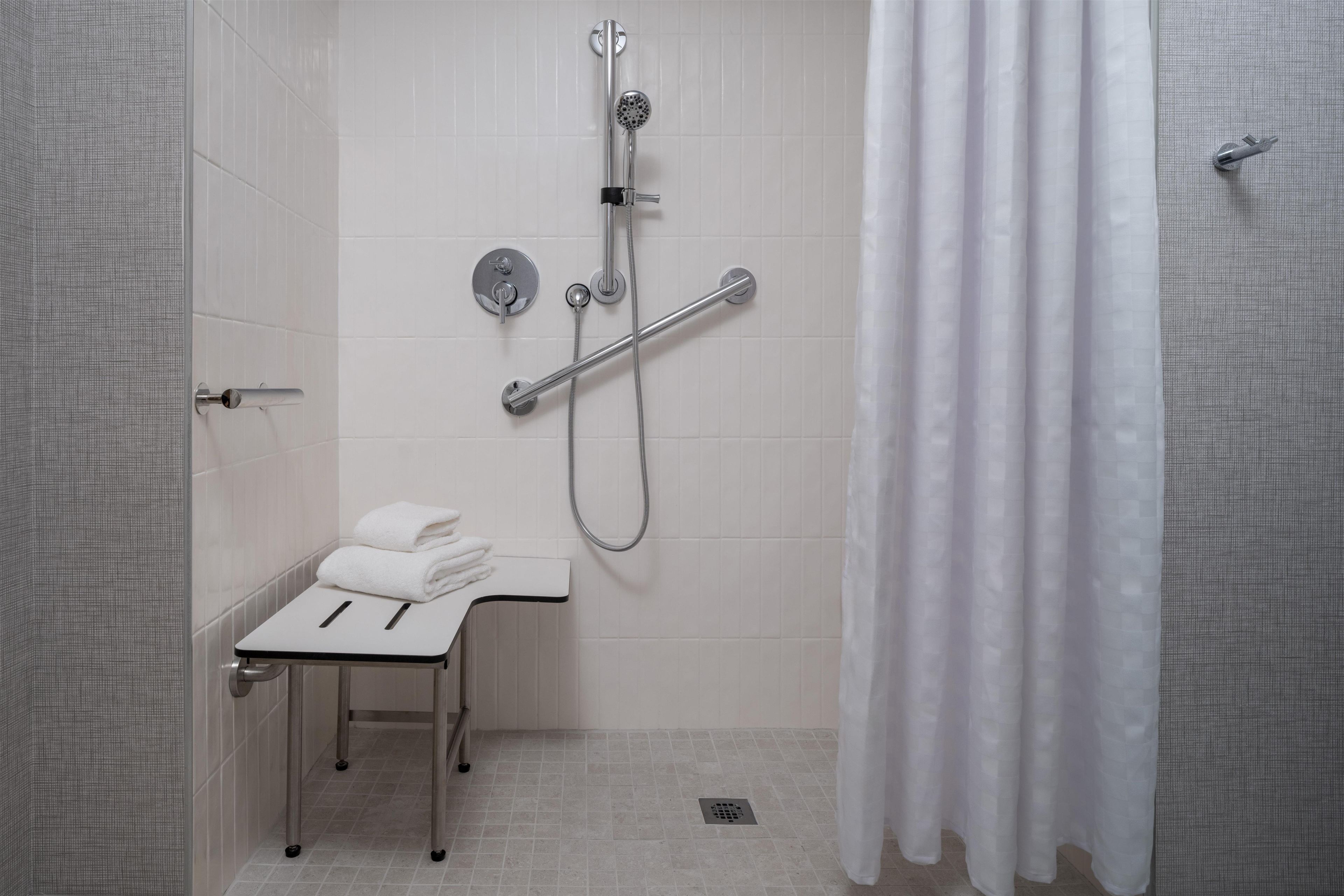 A modern bathroom with a shower, a toilet, and a sink.
