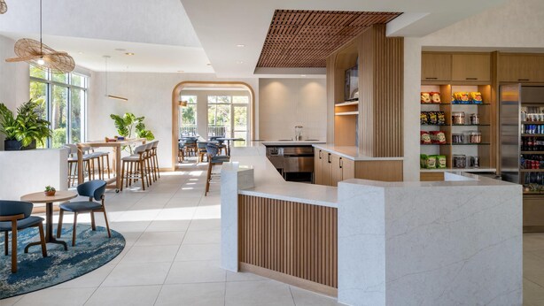A modern kitchen with a marble countertop, wooden cabinets, and a built-in pantry.