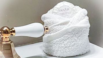 Una botella blanca con una etiqueta que dice "neclat" y un objeto blanco y esponjoso a su lado.