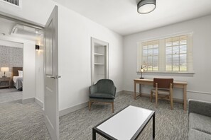 A hotel room with a bed, a desk, a chair, a table, a wardrobe, and a window with blinds. - Waynesville Inn and Golf Club, Tapestry Collection by Hilton (Waynesville)