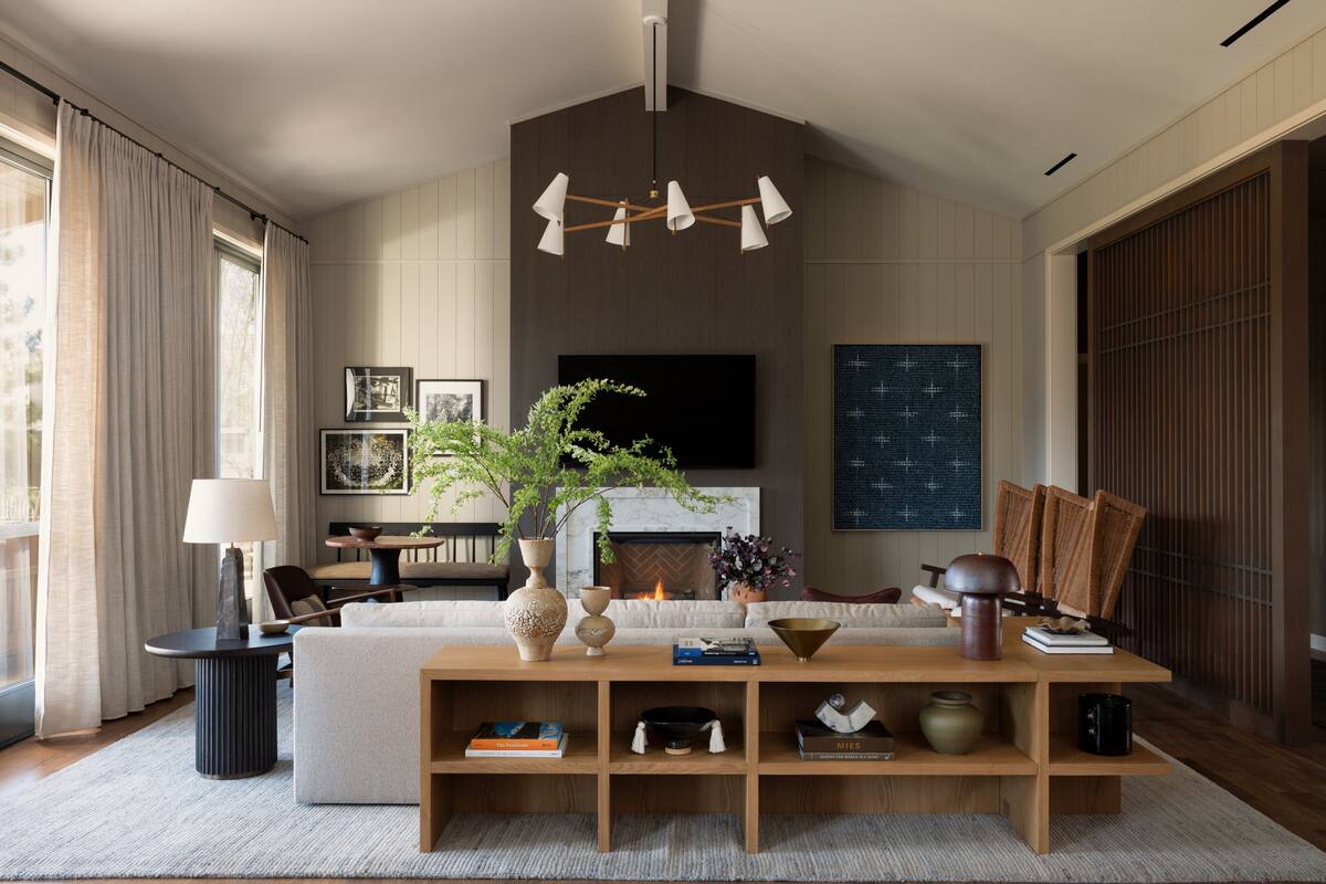 Una sala de estar moderna con chimenea, televisor grande y una mesa de centro de madera.