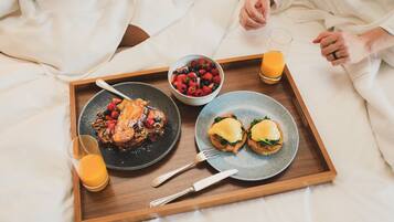 A tray with breakfast items on a bed.