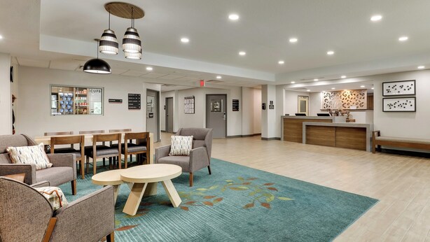 A spacious lobby with seating areas, a reception desk, and a coffee shop. - Candlewood Suites Lexington by IHG (Lexington)