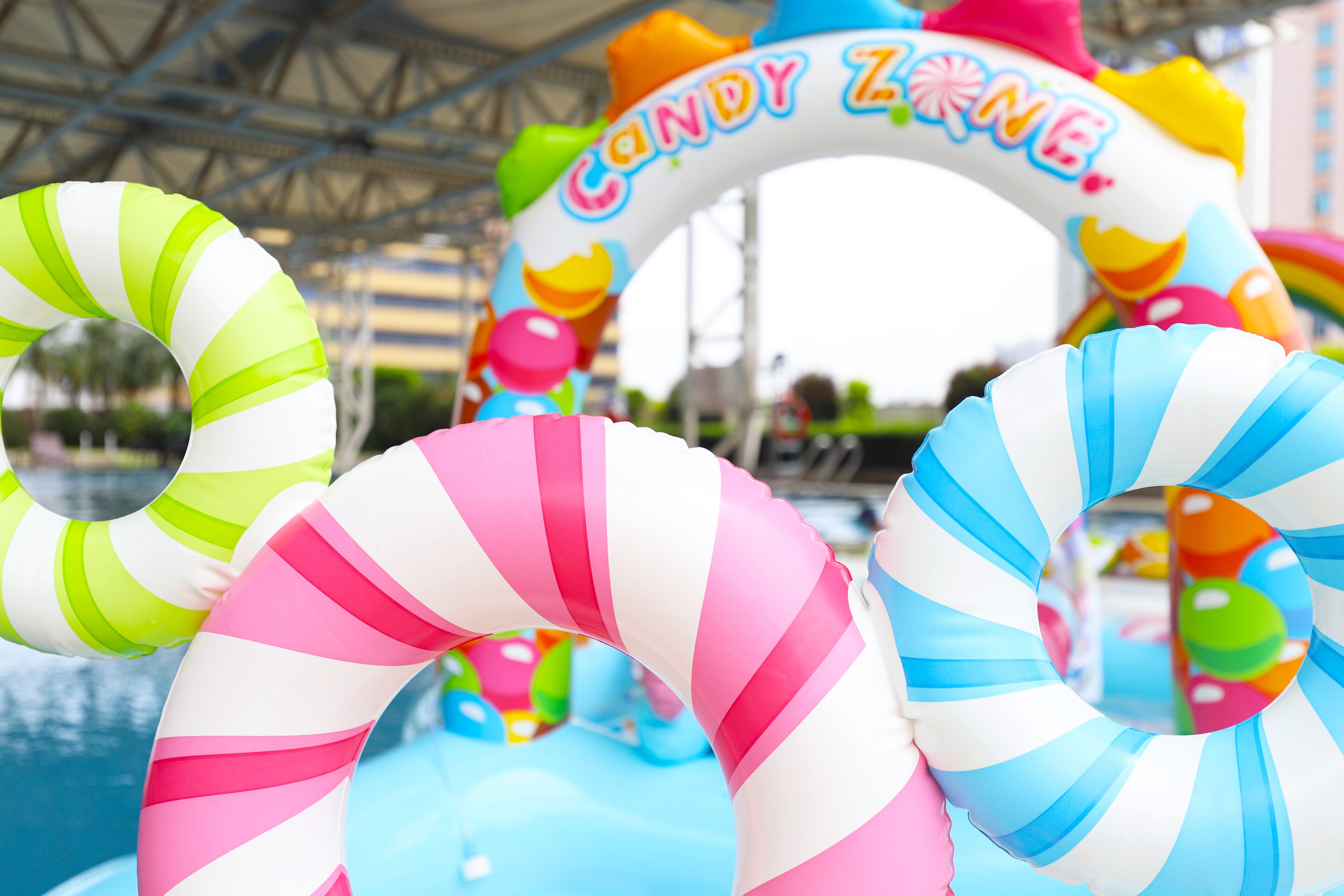 A pool area with inflatable rings and a 'Candy Zone' sign.