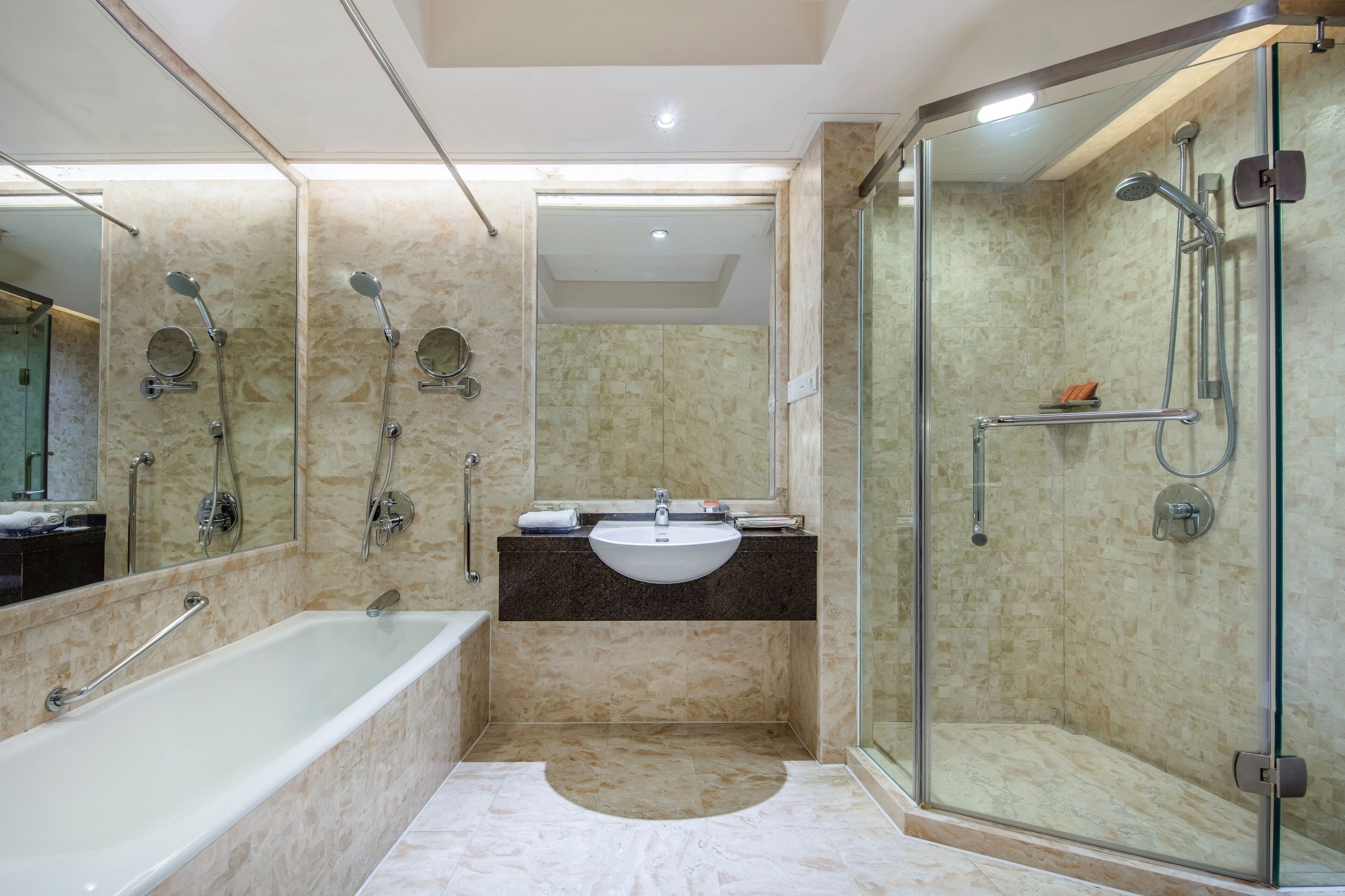 A modern bathroom with a bathtub, a sink, and a glass-enclosed shower area.