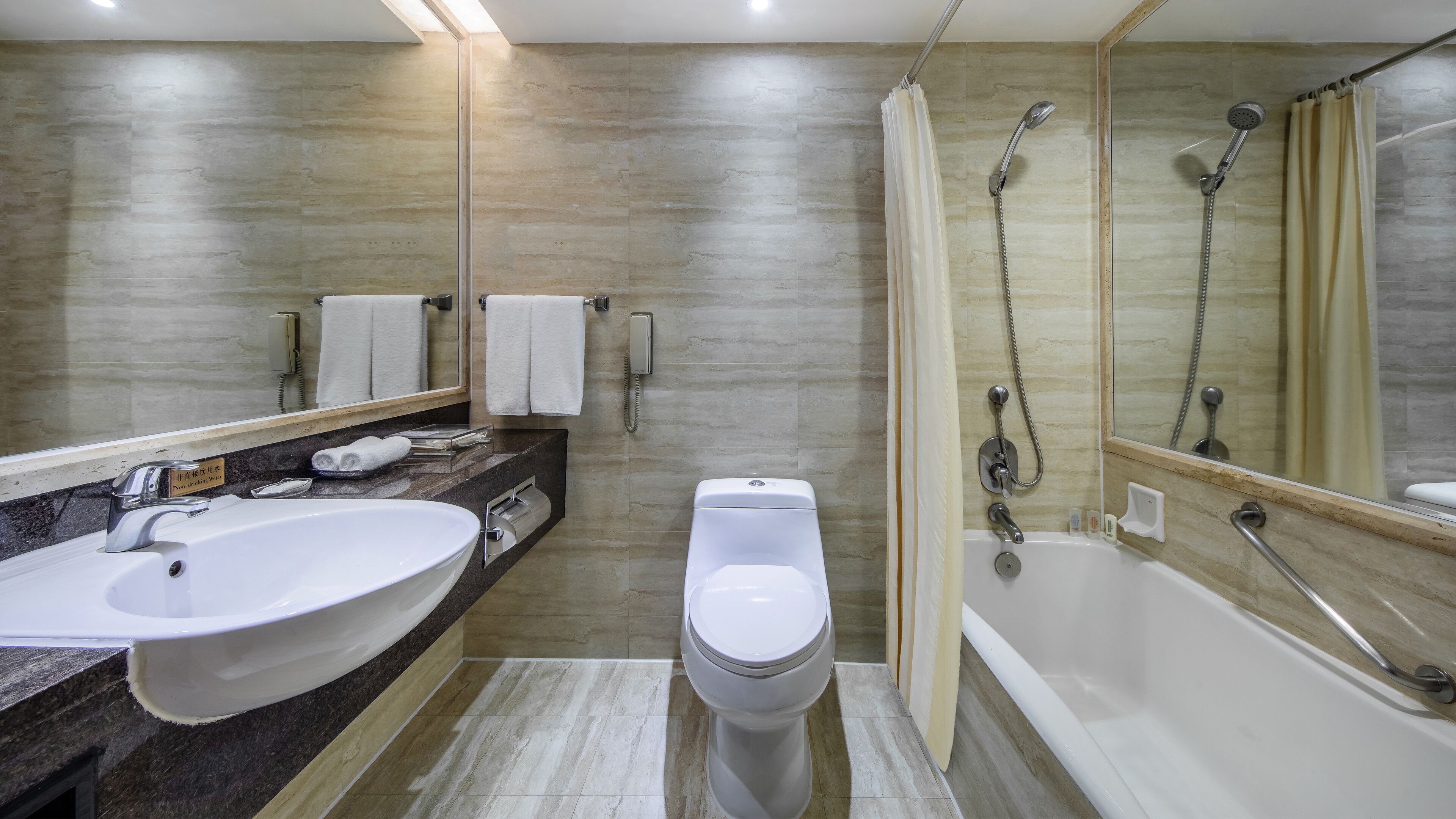 Un baño moderno con un lavamanos grande, inodoro y bañera.