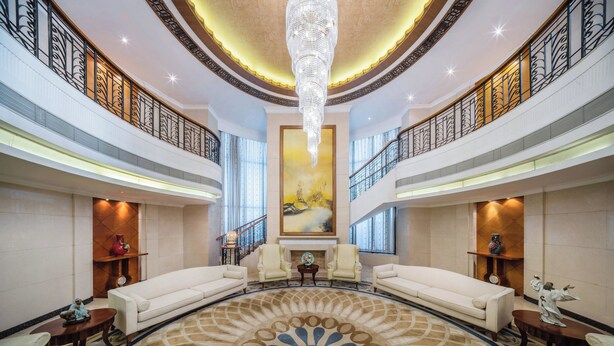 A spacious lobby with a large chandelier, two sofas, a fireplace, and a large painting on the wall. - Crowne Plaza Foshan by IHG (Foshan)
