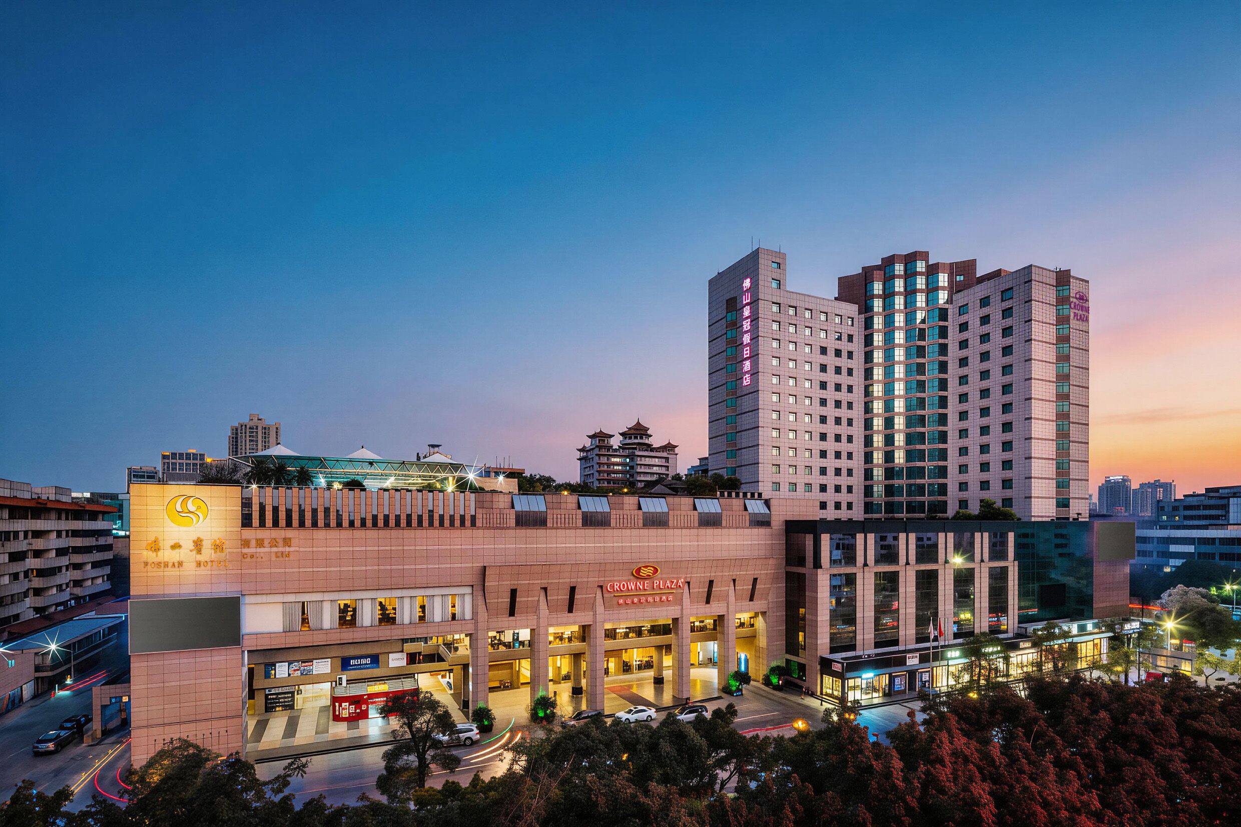Un hotel con una fachada moderna, varios pisos y un letrero llamativo de Crowne Plaza.