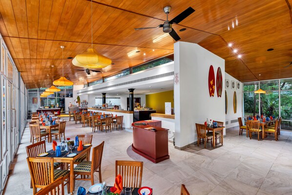 Um restaurante amplo com teto de madeira e mesas preparadas para refeições.