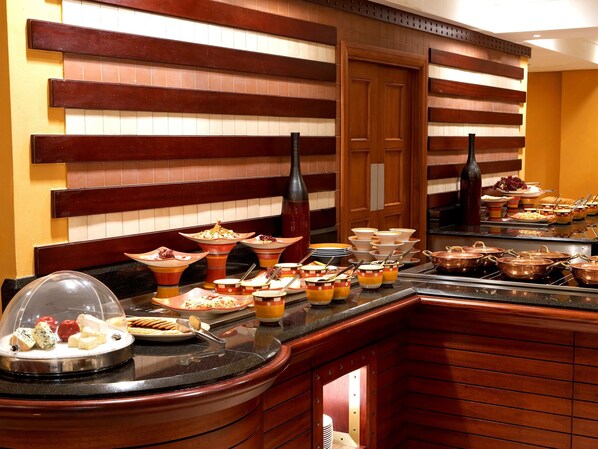 A buffet setup with various food items and utensils.