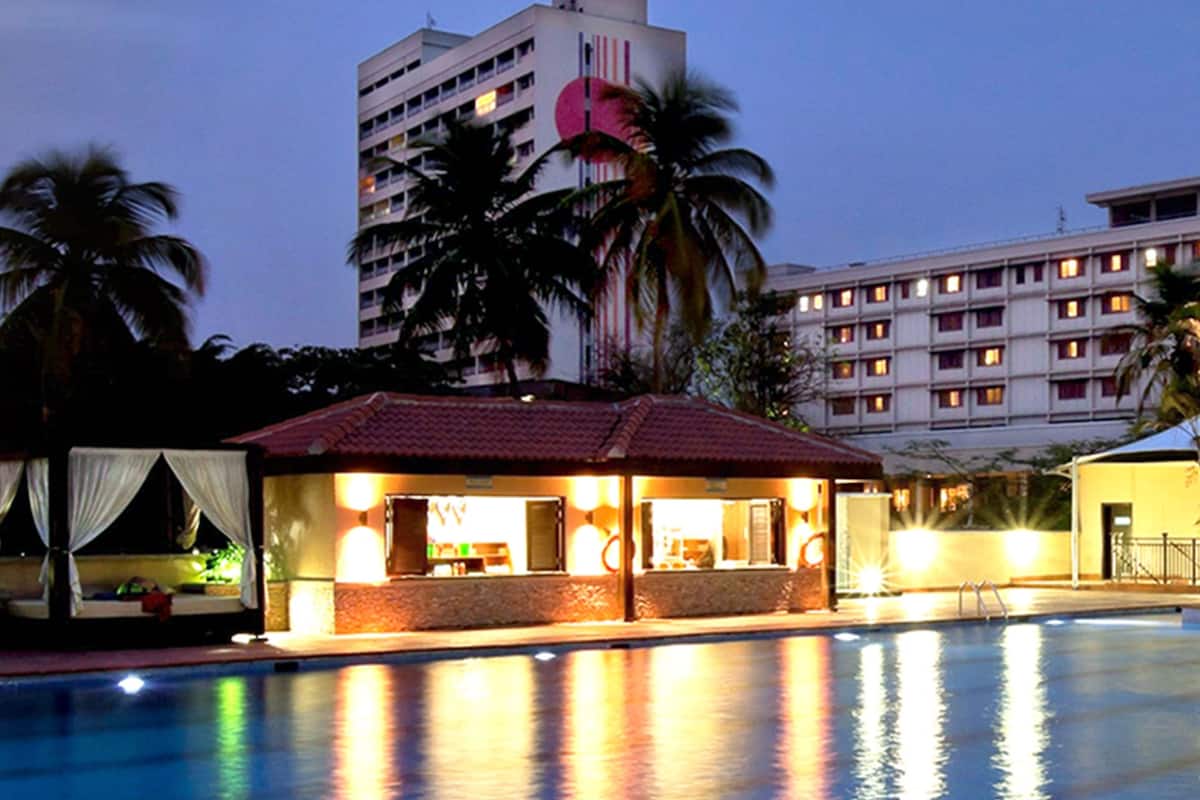 A hotel pool area with a bar and a building in the background.