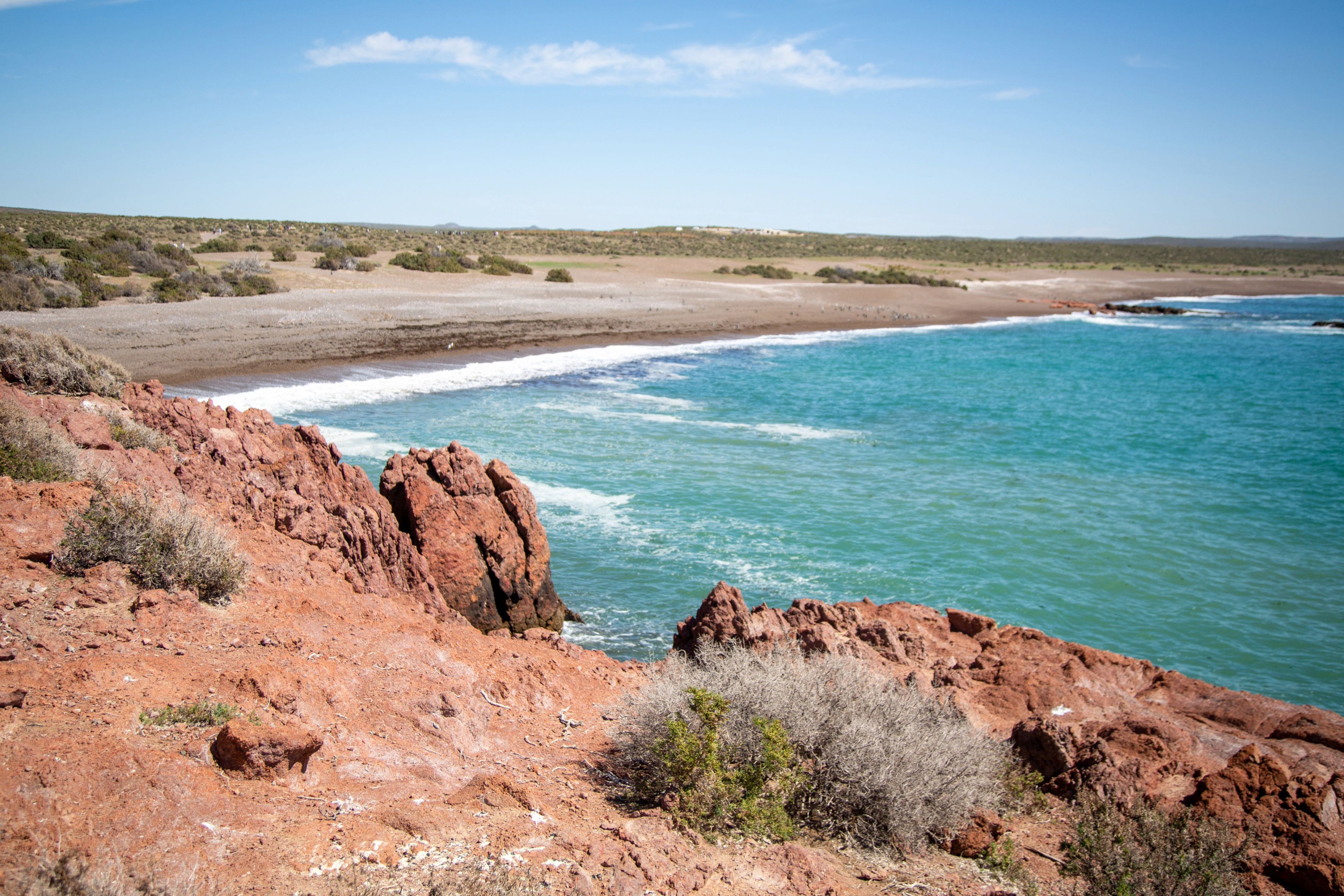 A coastal landscape with rocky terrain and a beach.