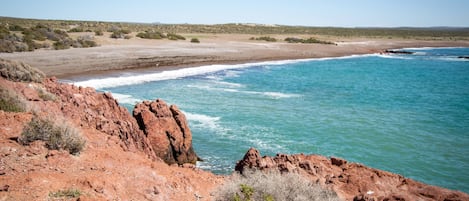 A coastal landscape with rocky terrain and a beach.