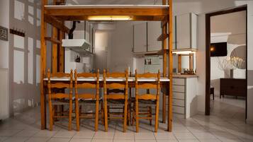 Una cocina moderna con una mesa y sillas de madera, armarios blancos y un horno empotrado.