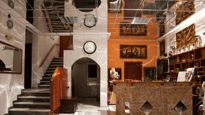 A lobby with a staircase, a reception desk, and a fireplace. - Saron Hotel (Lavreotiki)