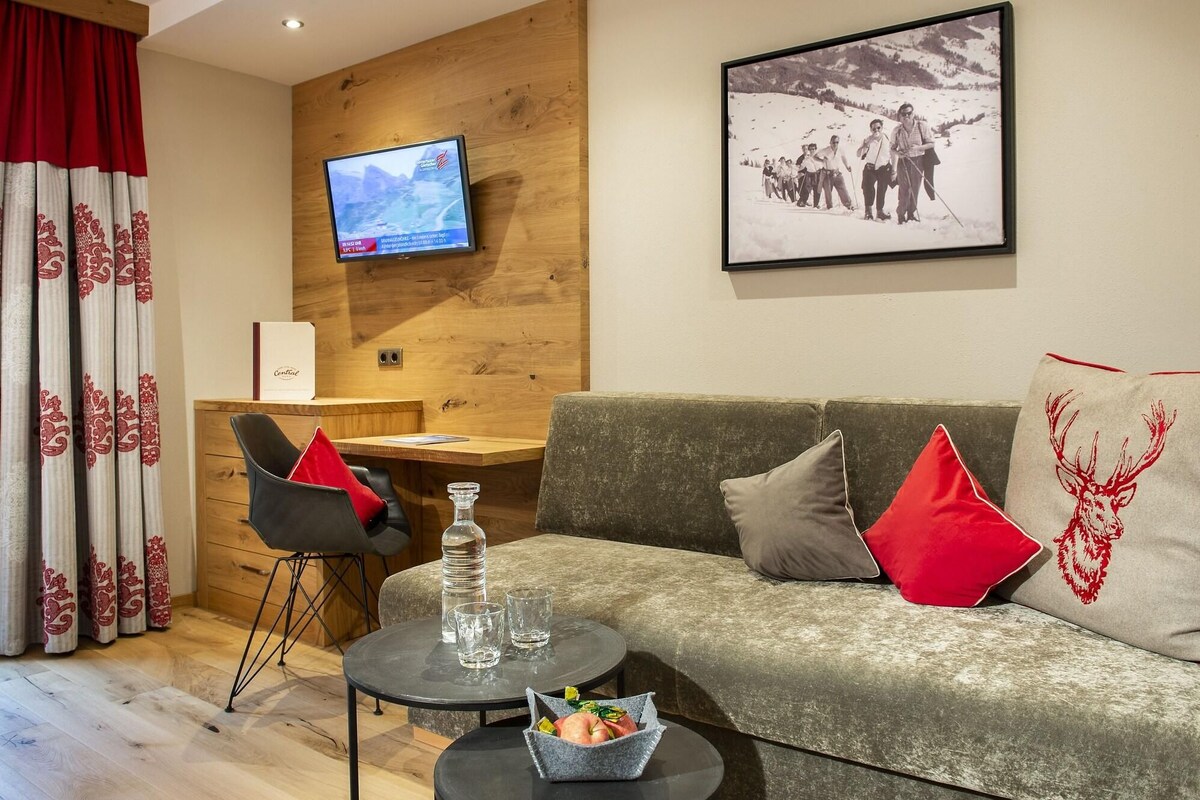 Una sala de estar moderna con un sofá, una mesa de centro, un televisor y una fotografía enmarcada en la pared.