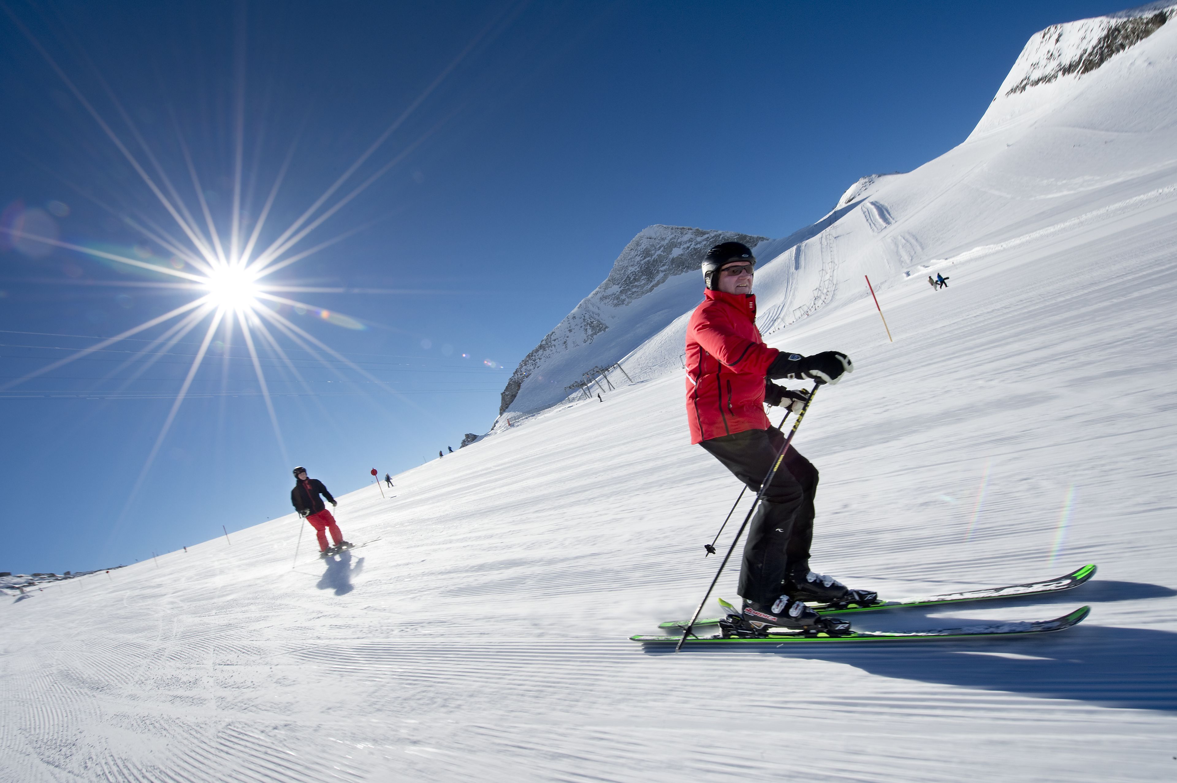 Pista de esquí nevada con esquiadores.