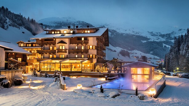 A multi-story hotel with a ski lift, surrounded by snow-covered mountains. - das Alois (Tux)