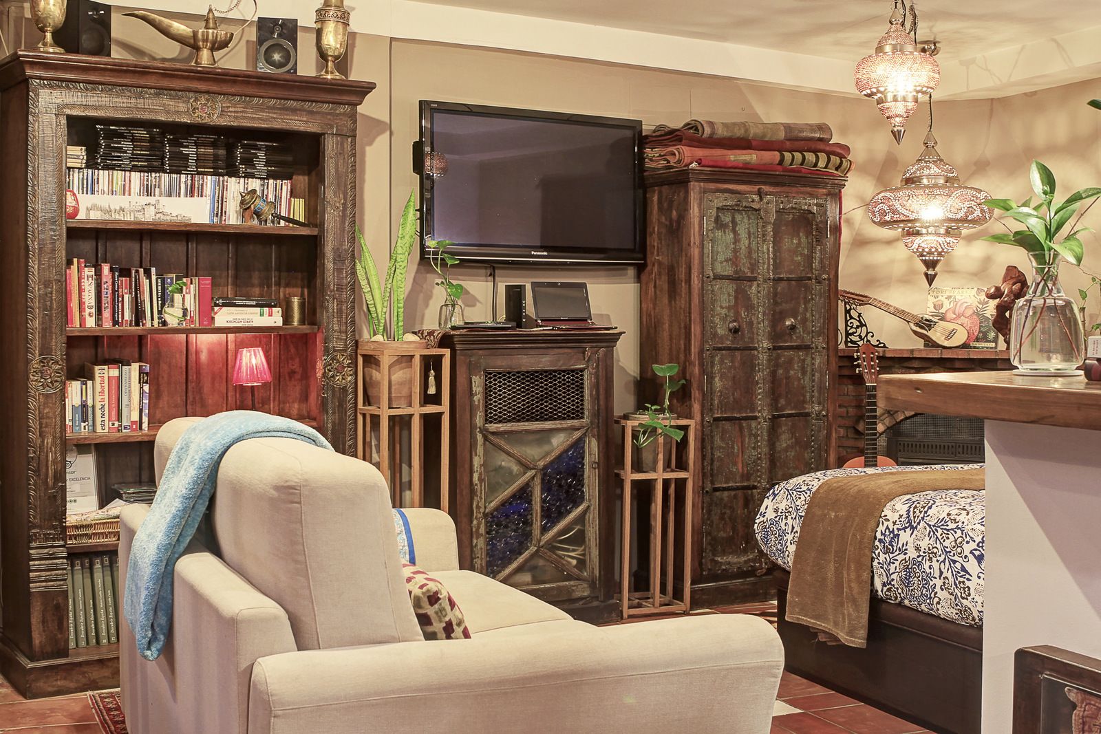Een gezellige woonkamer met een boekenkast, een open haard, een televisie en een decoratieve lamp.