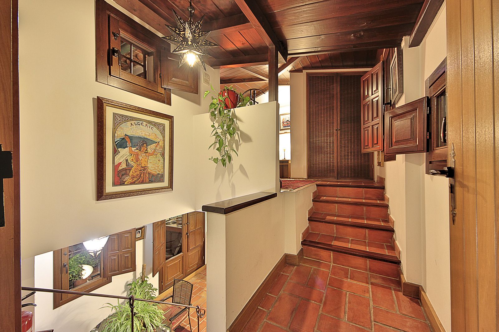 A staircase with wooden railings and a tiled floor leading to a room with wooden doors and a window with blinds.