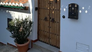 Un edificio con puerta de madera, una planta en maceta y un letrero que dice "vals MontesClara".