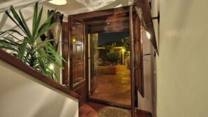 Una escalera de madera conduce a un patio con plantas en macetas y vistas al cielo nocturno.