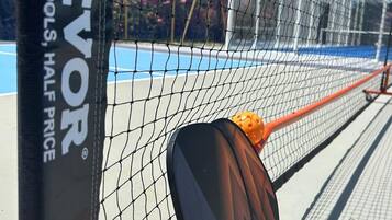 A tennis court with a net labeled "VEVO TOUGH TOOLS, HALF PRICE".