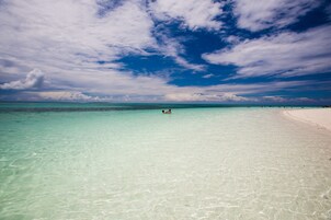 En la playa, arena blanca, sillas reclinables de playa