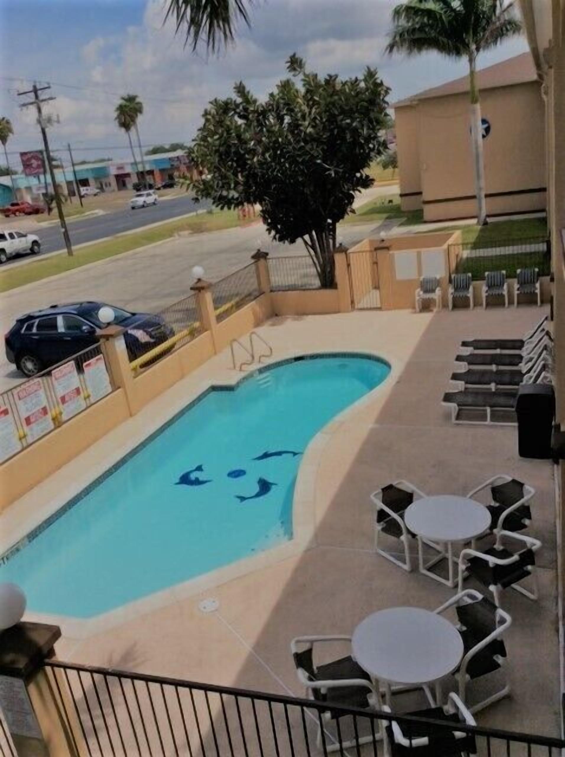 Una piscina al aire libre, sillones reclinables de piscina