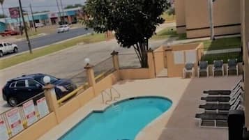 Una piscina al aire libre, sillones reclinables de piscina
