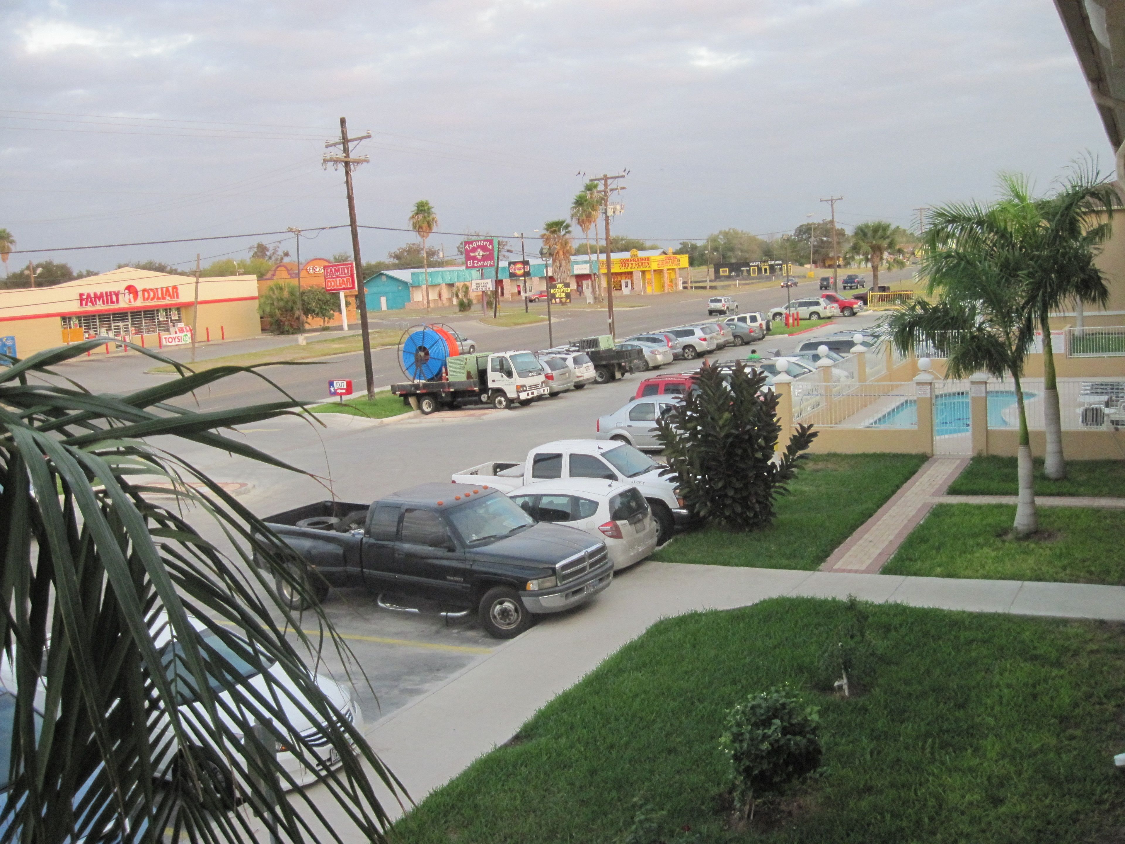 A parking lot with several cars, a truck, and a building with a sign that reads "Family Dollar".