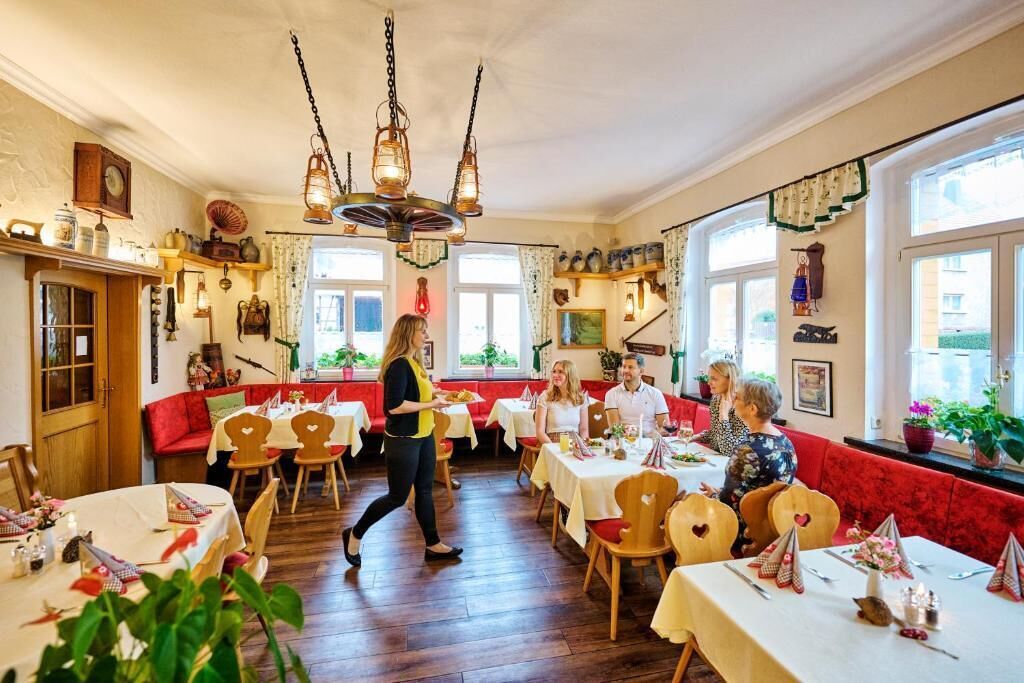 Ein Restaurant mit Holzböden, rot gepolsterten Sitzgelegenheiten und gedeckten Tischen.