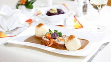 A plated dish with a sauce, a white spherical item, and a garnish.