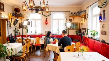 Un restaurante acogedor con sillas y mesas de madera, y un sofá rojo.