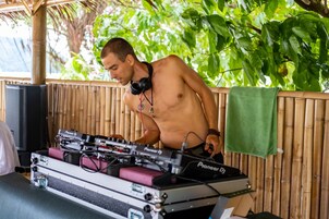 Ein DJ-Setup mit Pioneer DJ-Ausrüstung, Kopfhörern und einer Bambus-Kulisse.