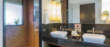 A modern bathroom with a glass-enclosed shower, two sinks, and a large mirror.