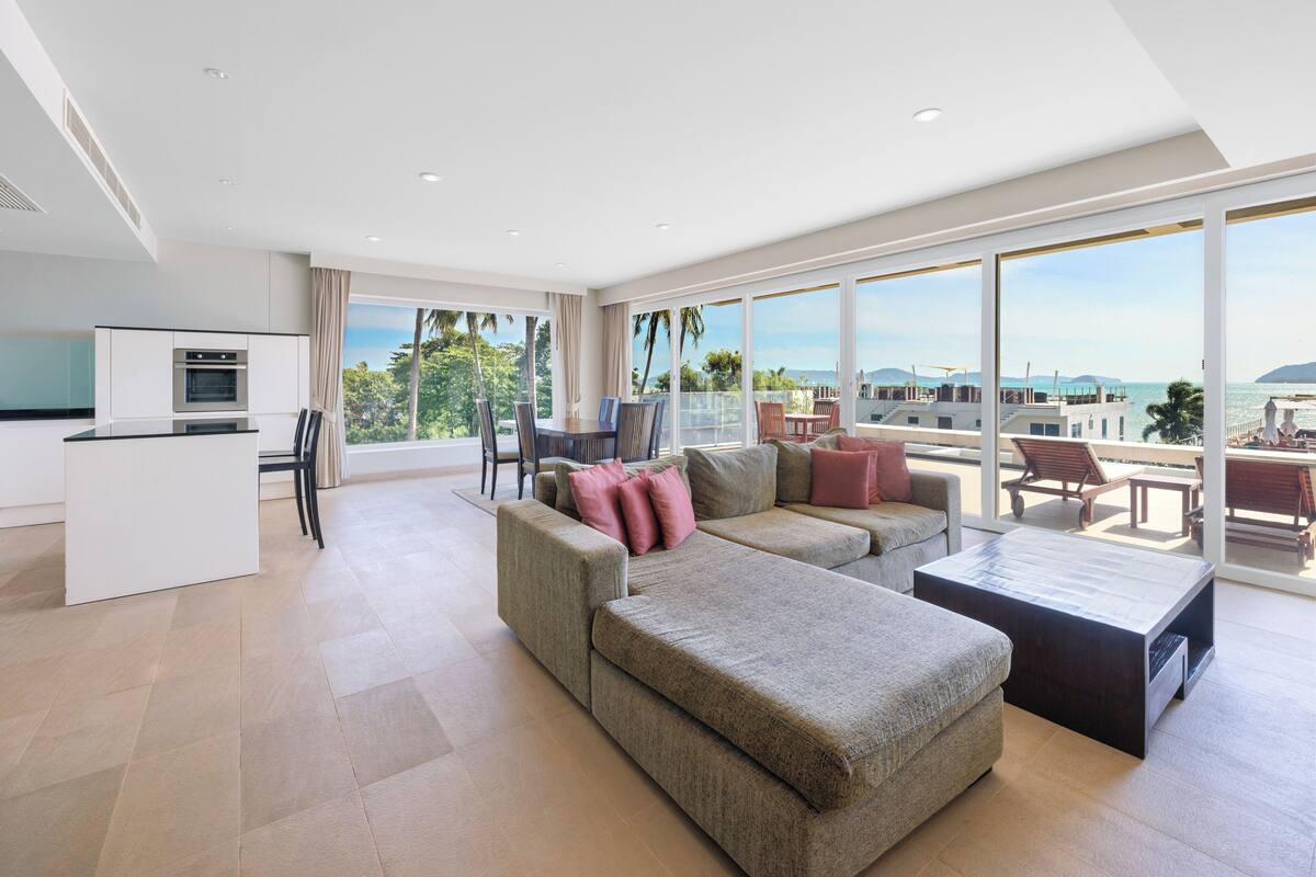 A modern living room with a sofa, coffee table, and dining area.
