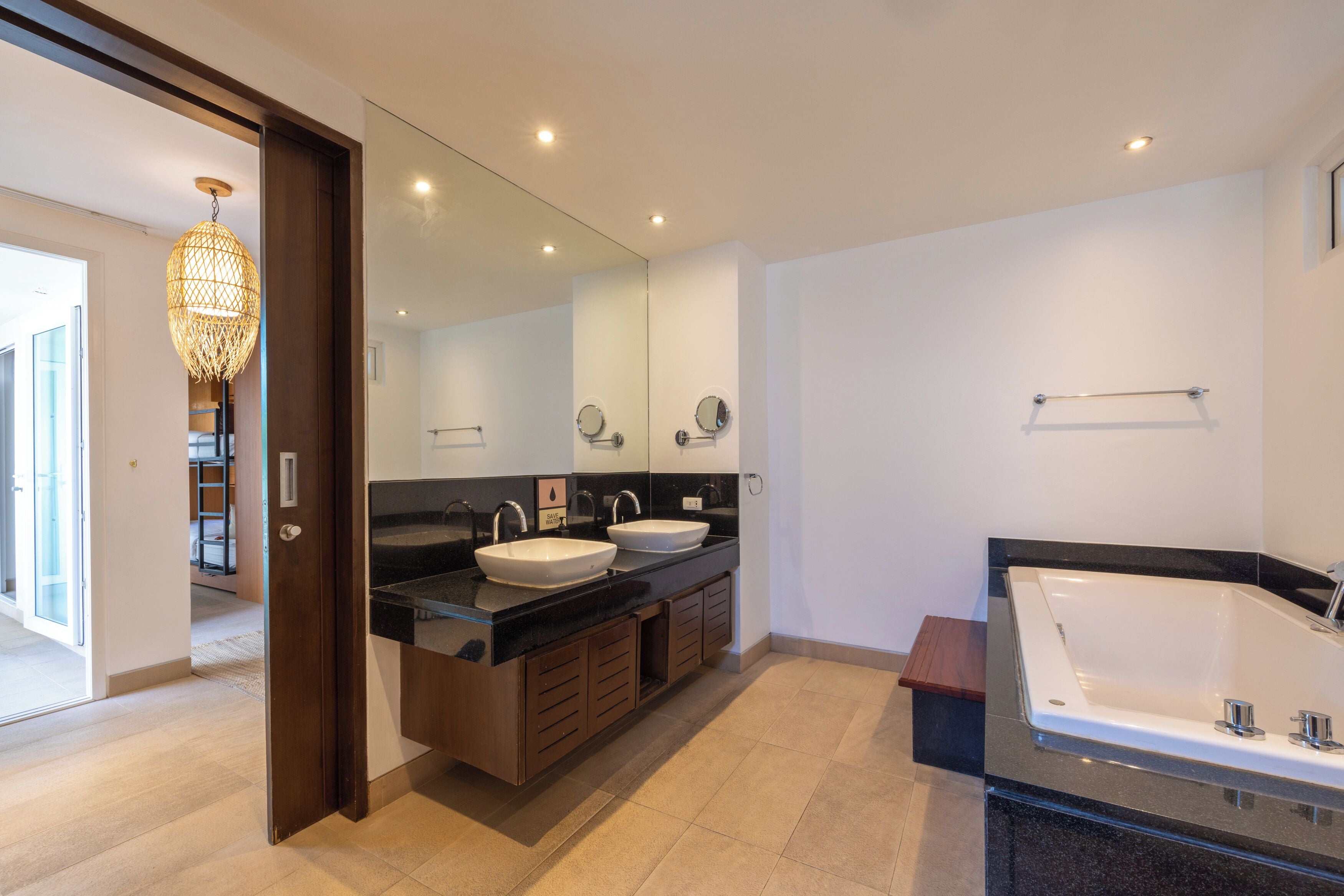 Une salle de bain moderne avec un meuble-lavabo à deux vasques, un grand miroir et une baignoire sur pieds.