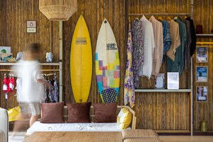 Una habitación con una cama, dos tablas de surf y un perchero.