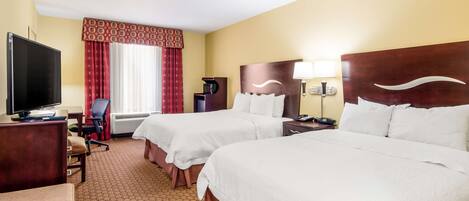 A hotel room with two beds, a TV, a desk, and a chair.