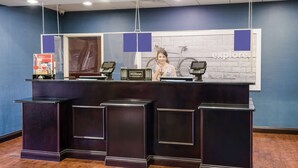 A reception desk with a 'Hilton Honors' sign, a bicycle in the background, and a 'Explore' sign on the wall. - Hampton Inn Galax (Galax)