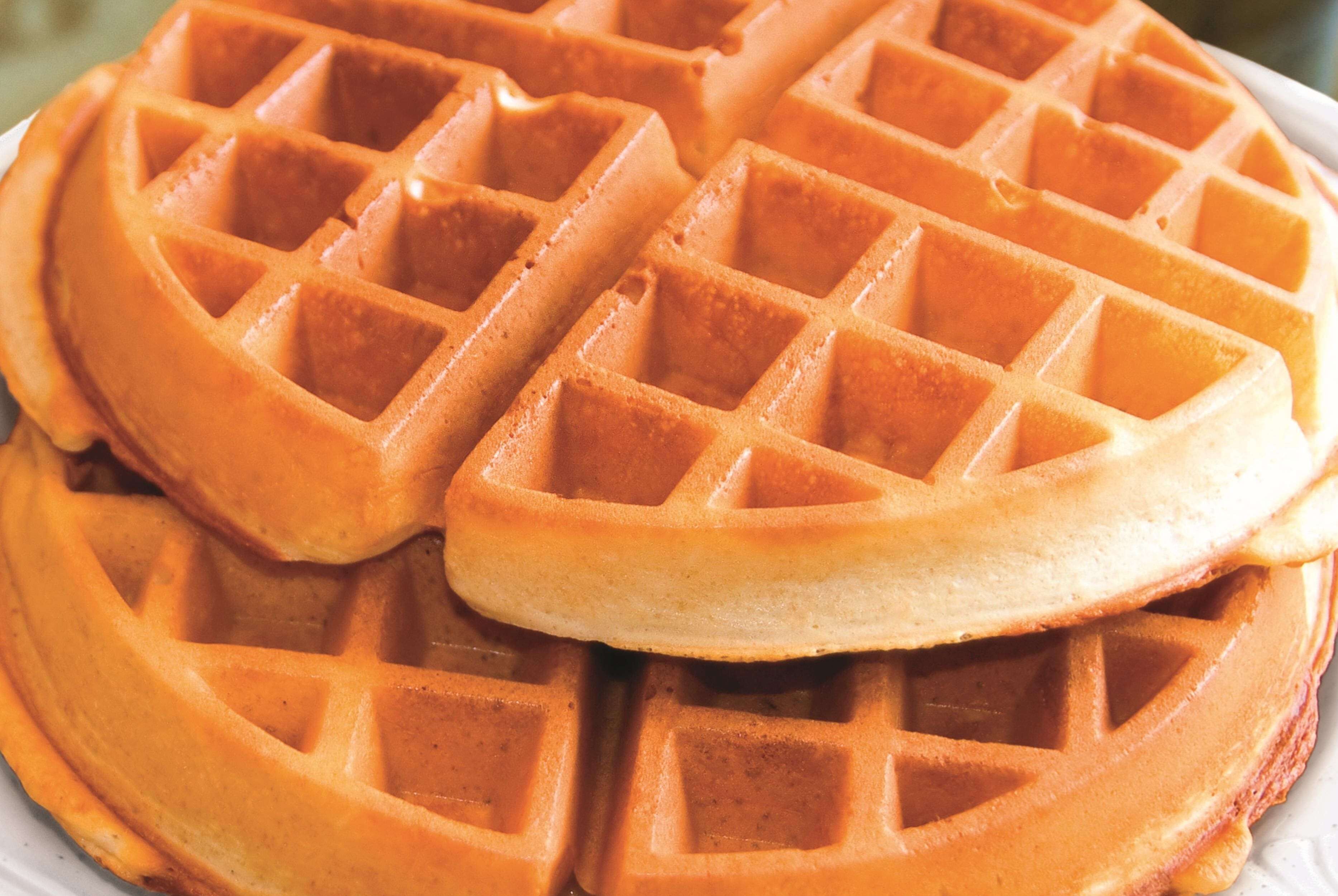 A close-up of a waffle with a golden-brown color and a grid pattern.