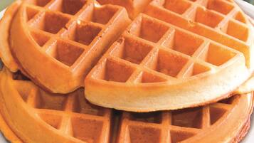 A close-up of a waffle with a golden-brown color and a grid pattern.