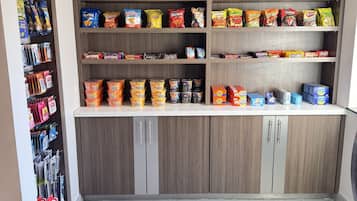 A kitchen with wooden cabinets and a countertop stocked with various snacks and packaged goods.