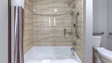 A modern bathroom with a bathtub, shower, and toilet.