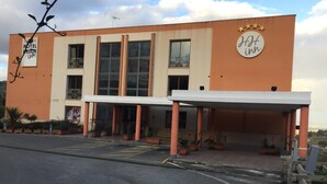 Et hotel med en moderne facade, store vinduer og et overdækket indgangsparti.