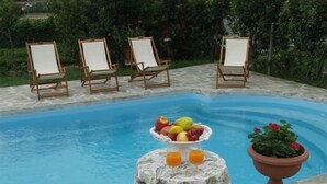 A swimming pool with four empty easels and a table with fruit and drinks. - Ca D Gnese (Castagnole delle Lanze)