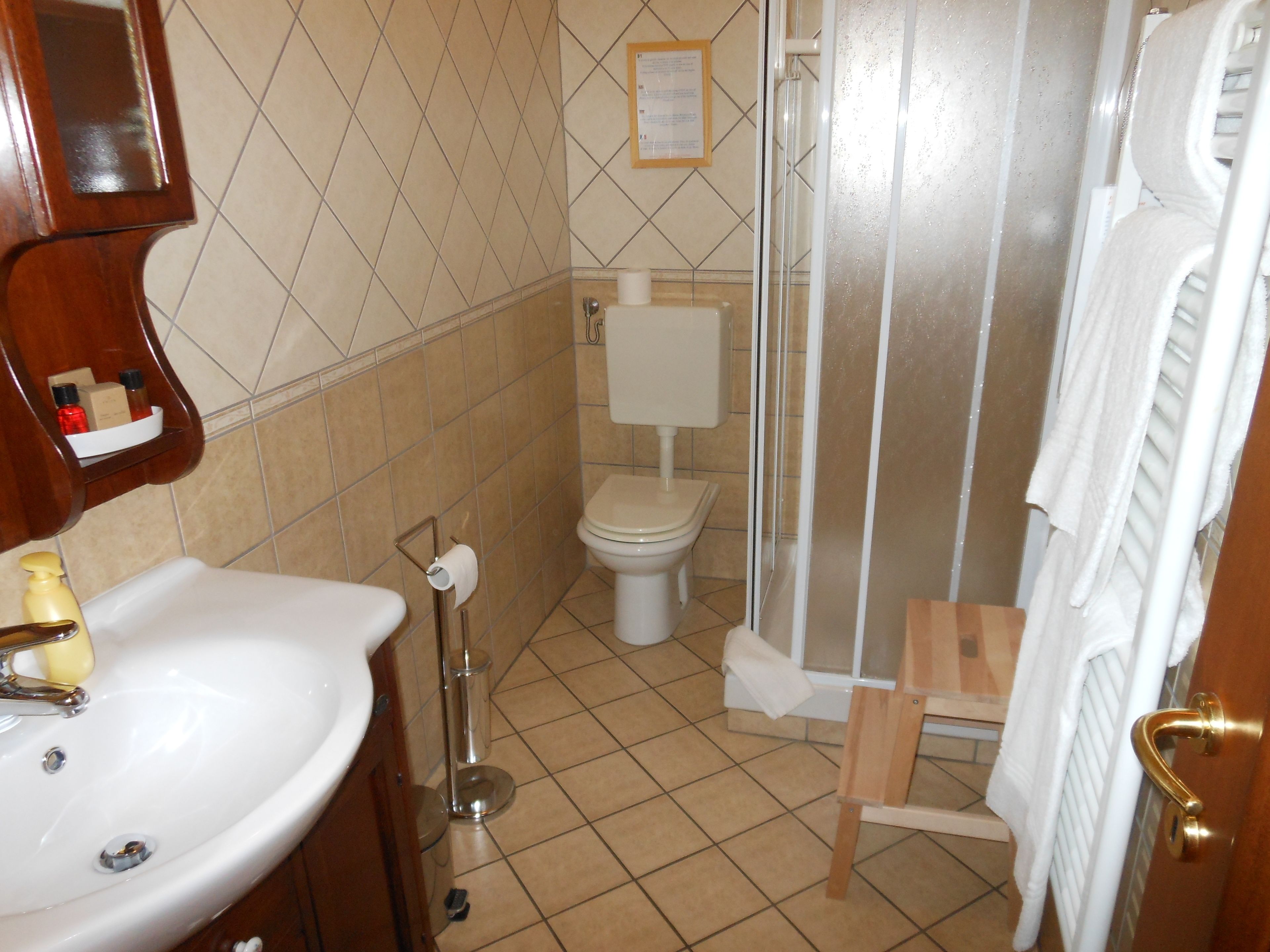 A bathroom with a sink, toilet, and shower area.