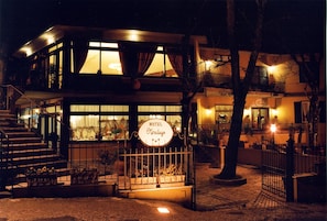 Ein Hotel mit einem Schild, auf dem 'HOTEL Miralago' steht, bei Nacht.