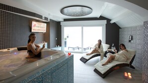 A wellness hotel with a large indoor pool, a massage chair, and a relaxation area with candles. - Hotel Biancaneve (Mondolfo)